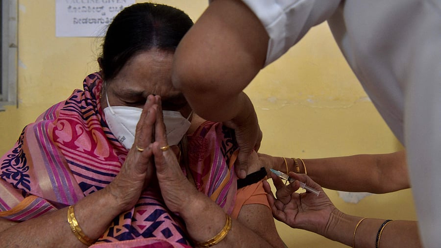 A health worker (R) inoculates a senior citizen with a Covid-19 coronavirus vaccine at a government hospital. Credit: AFP Photo