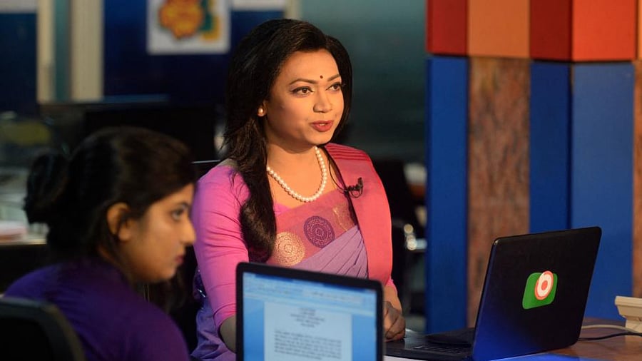 Tashnuva Anan Shishir (R) claimed to be Bangladesh's first transgender television news presenter presents the news on television at a news studio in Dhaka on March 8, 2021. Credit: AFP Photo