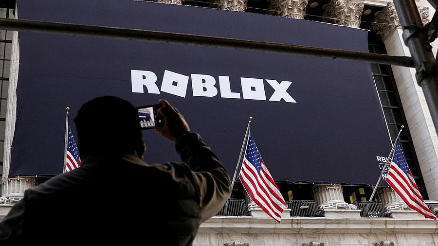 A man photographs a Roblox banner displayed, to celebrate the company's IPO, on the front facade of the New York Stock Exchange (NYSE) in New York. Credit: Reuters Photo