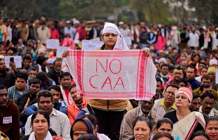 A demonstrator holds a piece of cloth locally known as "Gamosa" during a protest against a new citizenship law in Nagaon district in the northeastern state of Assam. Credit: Reuters Photo
