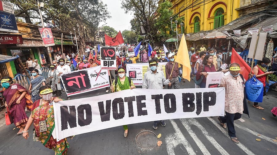 Activists hold a banner during a protest rally against BJP ahead of the West Bengal Assembly Polls. Credit: PTI Photo