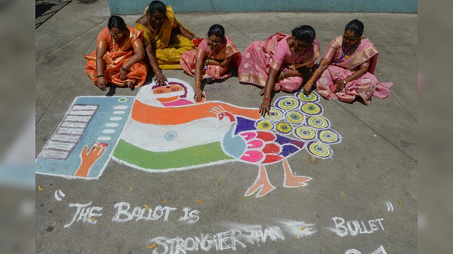 Electoral workers draw a rangoli during an election rally ahead of the Tamil Nadu legislative assembly elections, in Chennai on March 8, 2021. Credit: AFP Photo