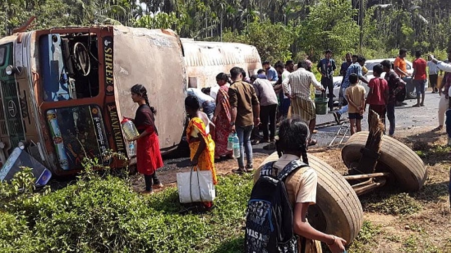 People collect diesel from a tanker that had turned turtle at Bollaru in Uppinangady. Credit: DH Photo