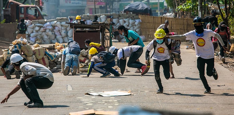 Protesters run during a crackdown by security forces. Credit: AFP Photo