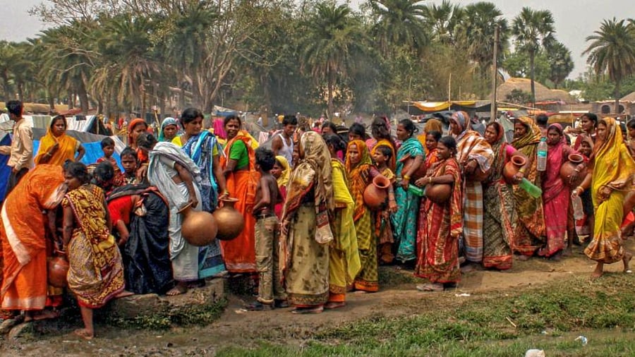 Village women lined up to collect drinking water from a well during the summer season, on the outskirts of Suri in Birbhum district of West Bengal. Credit: PTI Photo