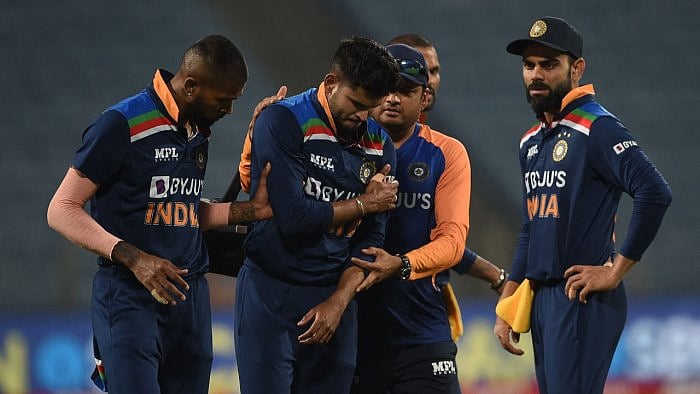 India's Shreyas Iyer (2L) reacts after injuring his shoulder while fielding during the first ODI between India and England in Pune. Credit: AFP Photo