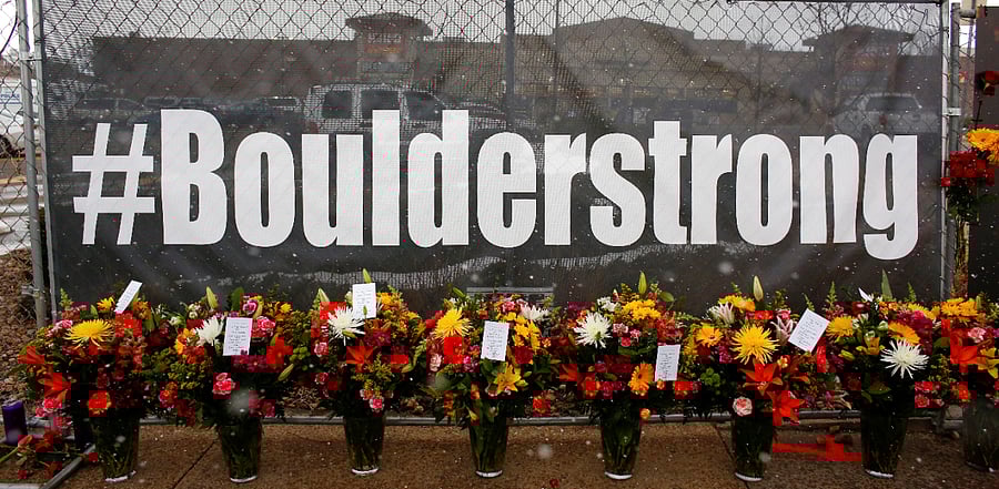 People leave flowers at the site of a mass shooting at King Soopers grocery store in Boulder. Credit: Reuters Photo