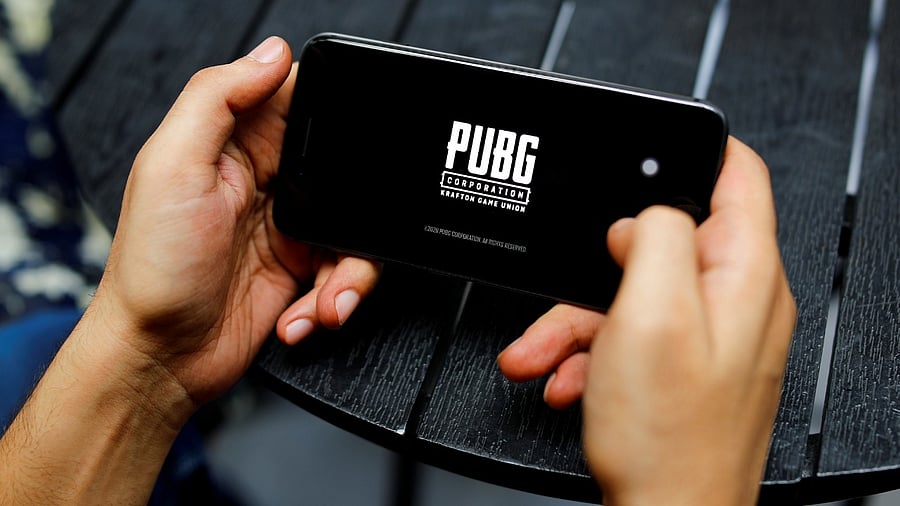 A boy plays Tencent Holdings' PUBG videogame on his mobile phone at a cafe in New Delhi. Credit: Reuters Photo