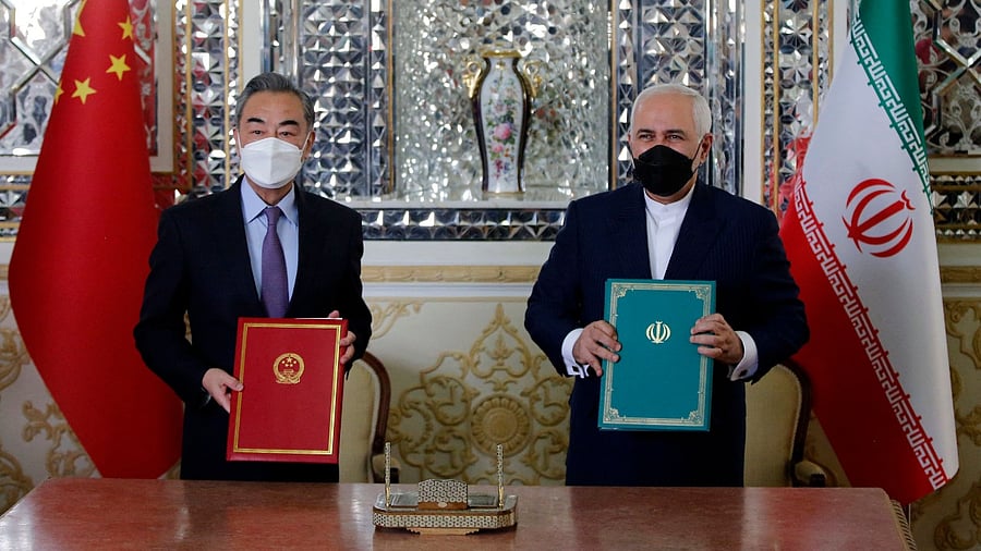 Iranian Foreign Minister Mohammad Javad Zarif (R) and his Chinese counterpart Wang Yi, pose for a picture after signing an agreement in the capital Tehran. Credit: AFP Photo
