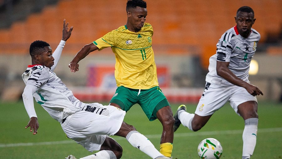South Africa's Themba Zwane (C) is tackled by Ghana’s Ismail Abdul-Ganui (R) during the 2021 African Cup of Nations qualifying football match between South Africa and Ghana at FNB Stadium in Johannesburg on March 25, 2021. Credit: AFP Photo