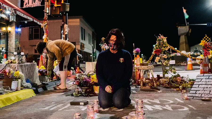 Courtney Ross, girlfriend of George Floyd, lays candles in the intersection of 38th St. & Chicago Ave. Credit: AFP Photo