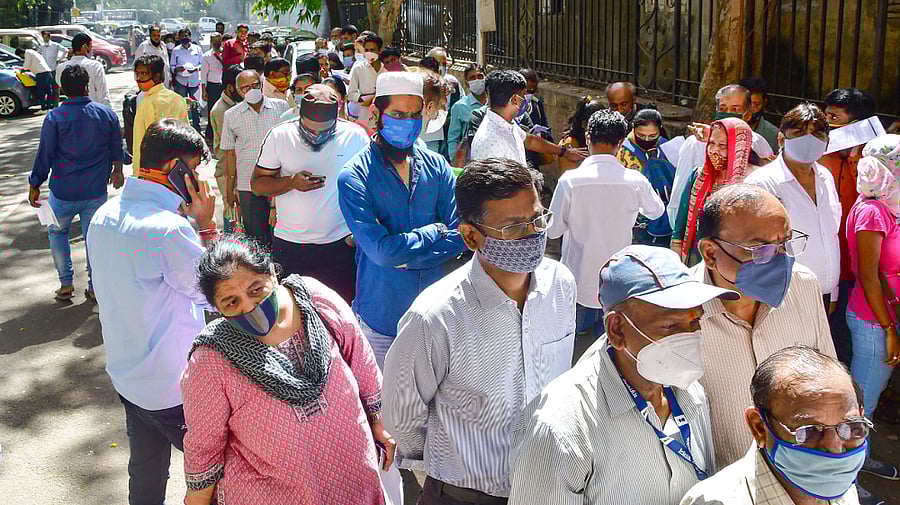 Staff members and others visiting a Sessions Court stand in a queue to register themselves for Covid-19 tests. Credit: PTI Photo