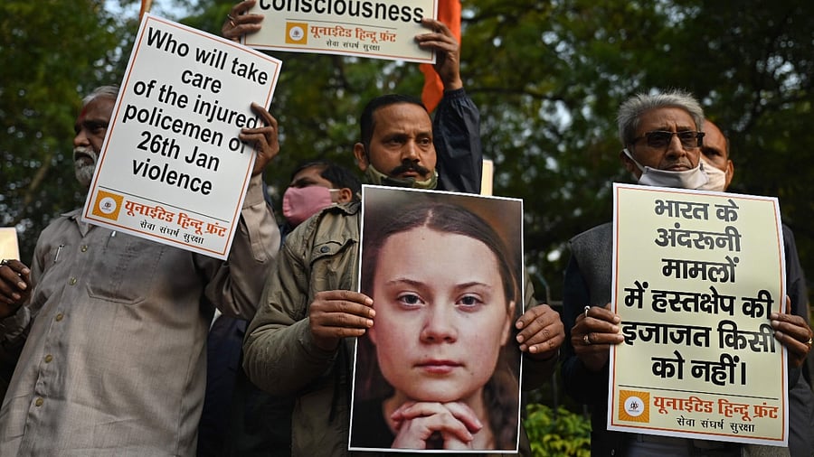 Activists of United Hindu Front (UHF) hold placards and a picture of Swedish climate activist Greta Thunberg during a demonstration in New Delhi. Credit: AFP File Photo.