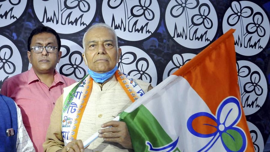 West Bengal Panchayat and Rural Development Minister Subrata Mukherjee (L) hands over the party flag to former BJP leader Yashwant Sinha (R). Credit: PTI Photo