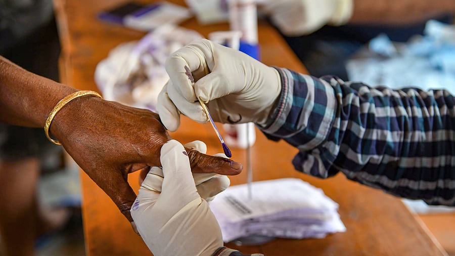 A polling official marks the finger of a voter in Assam. Credit: PTI Photo