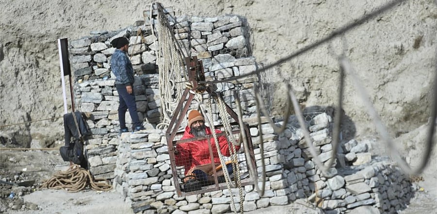A villager crosses a river on a manually operated trolley, recently installed by the PWD following the glacier burst at Joshimath which triggered a massive flash flood on Feb. 7, in Chamoli district of Uttarakhand, Tuesday, Feb. 16, 2021. Credit: PTI Photo