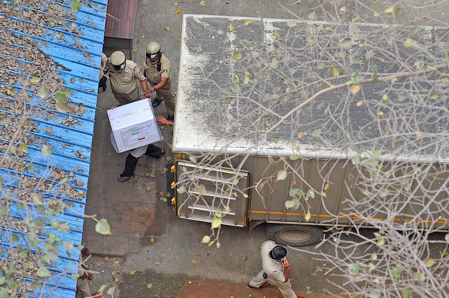 Covid-19 vaccine consignments being unloaded from the truck that arrived from the Kempegowda International Airport at the storage facility near Anand Rao circle, Bengaluru on Tuesday. Credit: DH Photo/Pushkar V