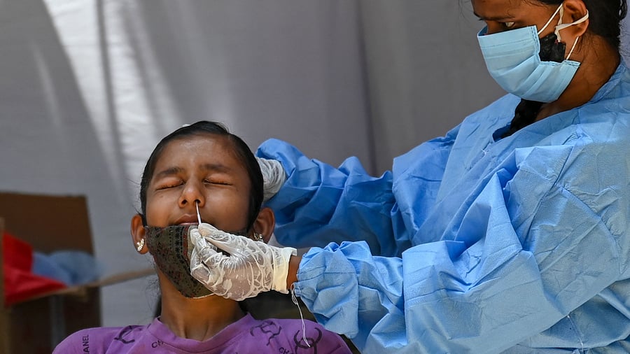 A healthcare worker collects nasal swab sample for Covid-19 test. Credit: DH Pool