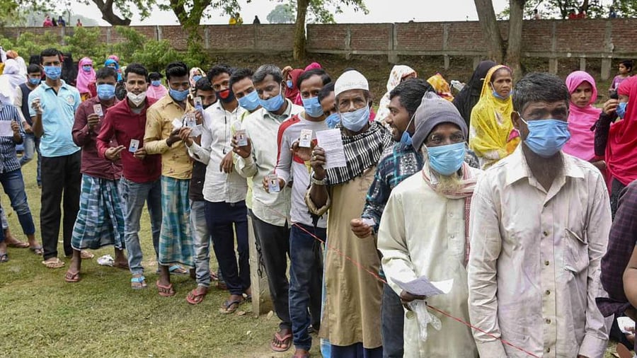Voters wait in queues to cast their votes at a polling station during the second phase of Assam Assembly elections, at Mayong in Morigaon, Thursday, April 1, 2021. Credit: PTI Photo