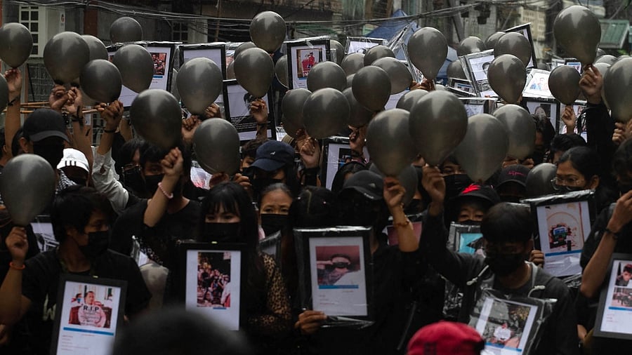 This photo taken and received from an anonymous source via Facebook on April 5, 2021 shows protesters holding up portraits of people who have died while taking part in the demonstrations against the military coup, at a rally in Yangon. Credit: AFP Photo