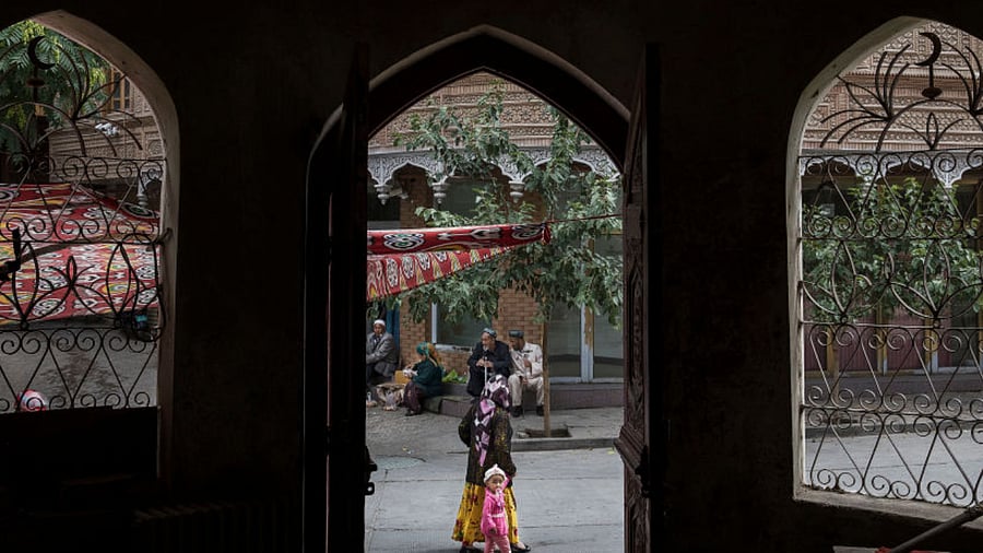 An ethnic Uyghur woman walks by the closed Islamic school on July 1, 2017 in the old town of Kashgar, in the far western Xinjiang province, China. Credit: Getty Images