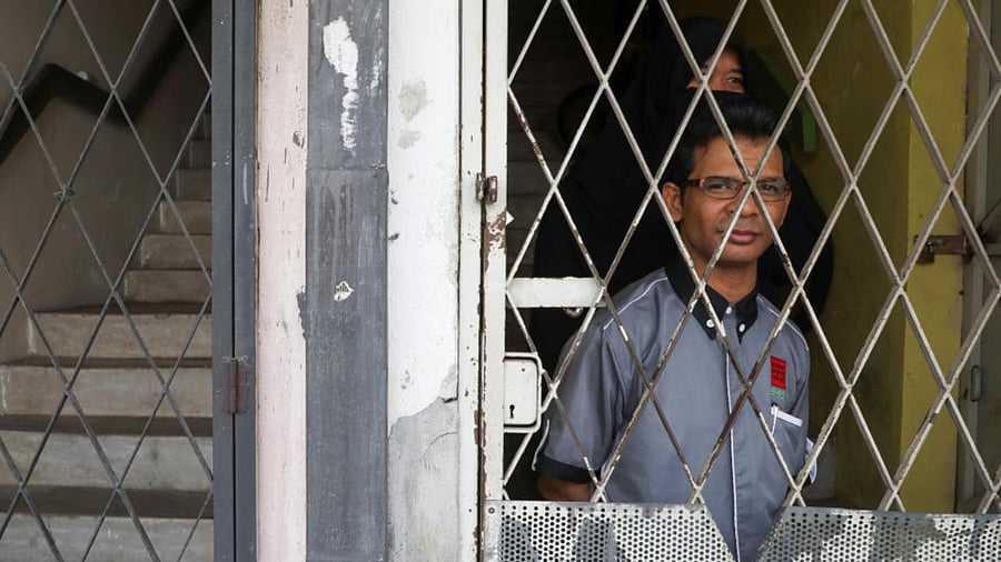 Rohingya refugee and activist Zafar Ahmad Abdul Ghani and his wife look out from their home in Kuala Lumpur, Malaysia March 19, 2021. Picture taken March 19, 2021. Credit: Reuters Photo