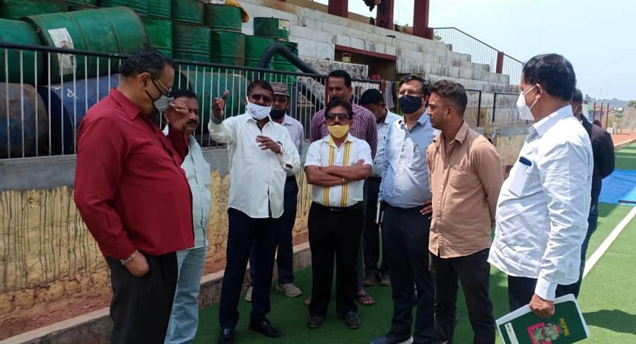 Karnataka sports authority vice-president K P Purushottam carries out an inspection of the synthetic turf hockey ground at Government PU College grounds in Somwarpet on Friday.
