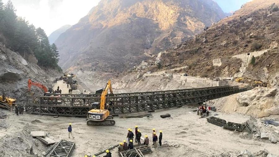 Border Roads Organisation (BRO) workers engaged in building a valley bridge over the Rishi Ganga River at Raini village of the disaster-hit Chamoli district. Credit: PTI photo.