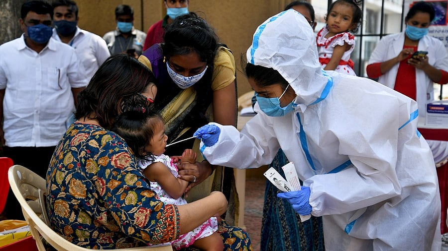 A medical worker collects swabs for Covid-19 test at an apartment in Adugodi, Bengaluru. Credit: DH Photo/Pushkar V