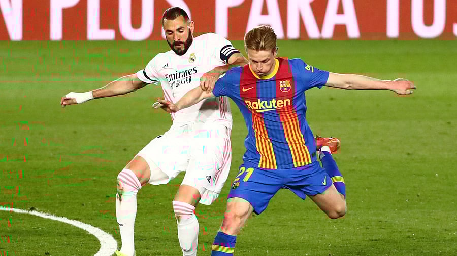 Real Madrid's Karim Benzema in action with Barcelona's Frenkie de Jong. Credit: Reuters Photo