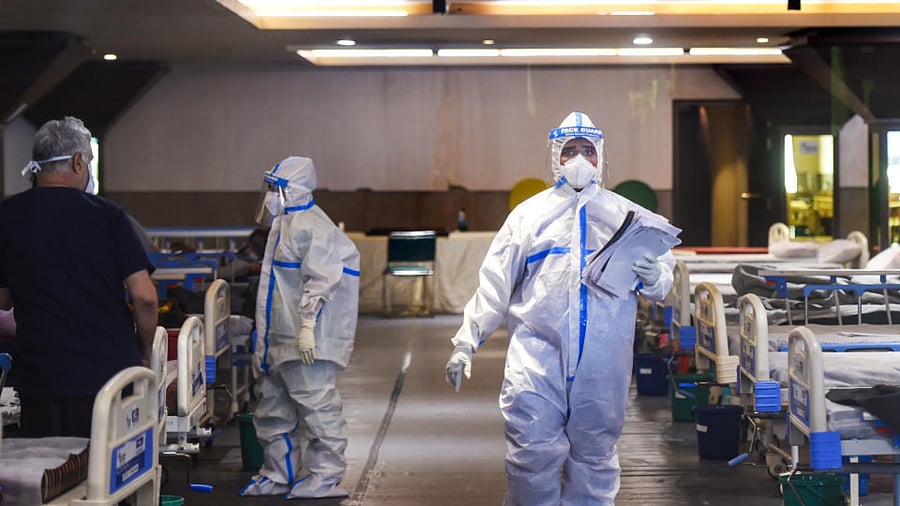  Medics attend to a Covid-19 patients at Shehnai Banquet Hall, temporarily converted into an isolation ward, as coronavirus cases surge across the country, near Low Nayak Jai Prakash (LNJP) Hospital in New Delhi, Tuesday, April 13, 2021. Credit: PTI Photo