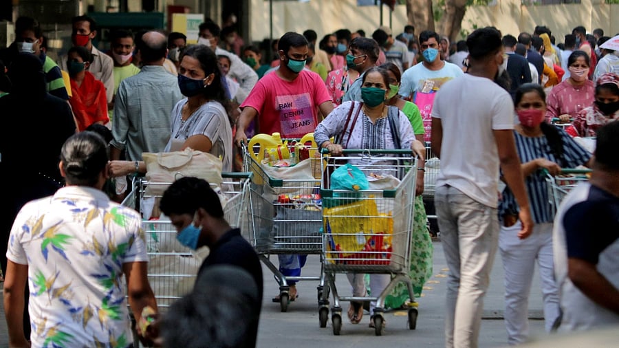 People push trolleys loaded with grocery items as others wait to enter a supermarket, amidst the spread of the coronavirus in Mumbai, India, April 14, 2021. Credit: Reuters Photo