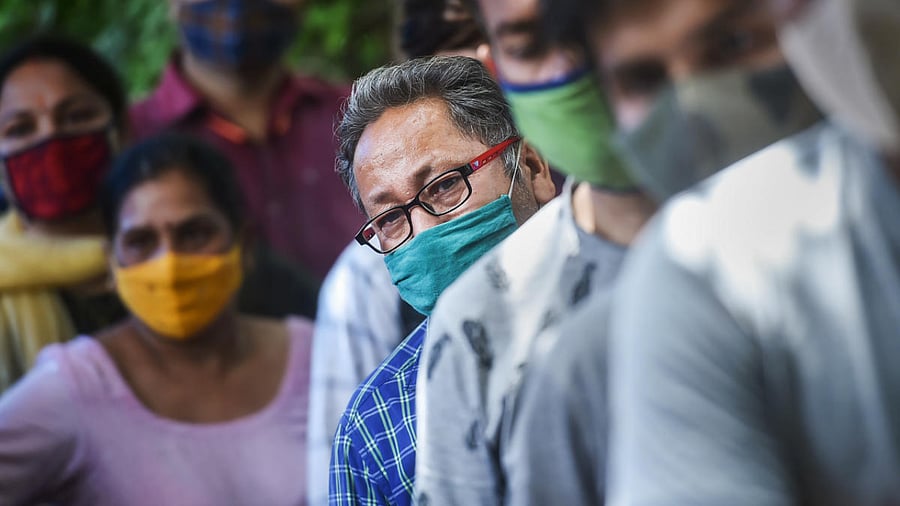 People wait for their turn to get tested for Covid-19 at a testing centre, as coronavirus cases surge across the country, at Vasundhara, in Ghaziabad. Credit: PTI photo. 