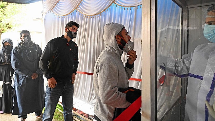 A health worker takes nasal swab samples from people to test for the Covid-19 coronavirus infection at a testing center in Srinagar. Credit: AFP Photo