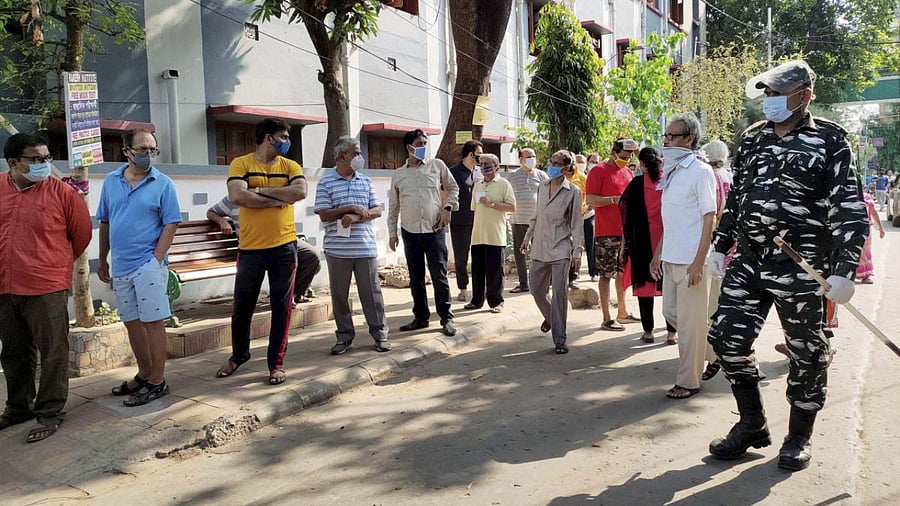 Security personnel stand guard at a polling station during the 5th phase of West Bengal state assembly polls, in South 24 Parganas district. Credit: PTI photo.