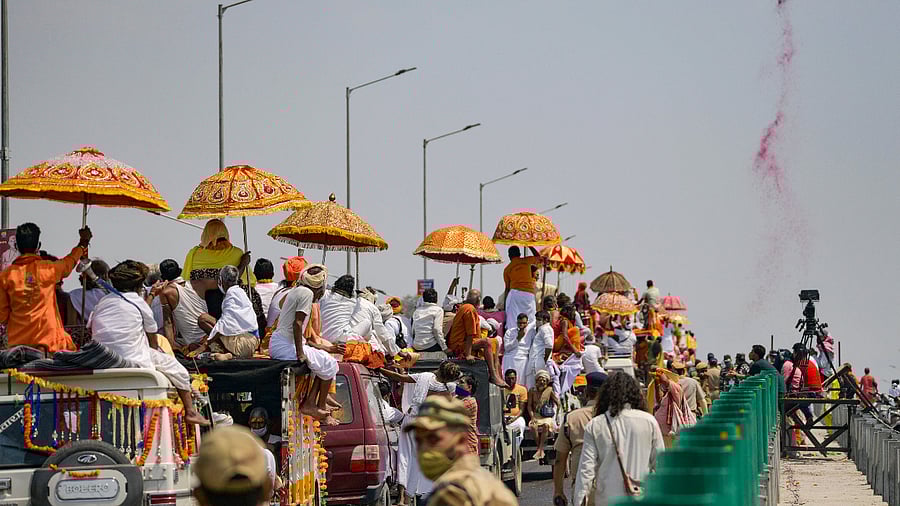 A chopper showers flower petals on Akhada sadhus arriving to take bath at Har Ki Pauri during 3rd Shahi Snan of ongoing Kumbh Mela 2021. Credit: PTI Photo