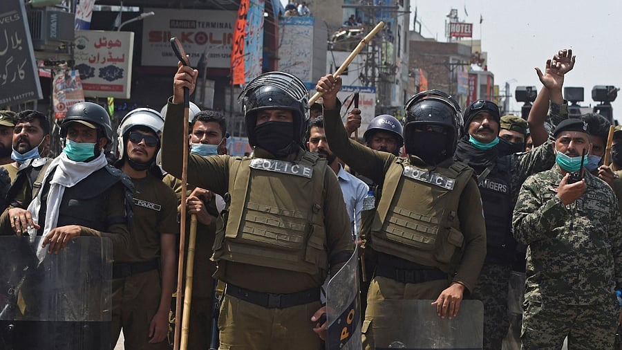 Security personnel gesture towards the supporters of Tehreek-e-Labbaik Pakistan (TLP) party during a protest. Credit: AFP Photo