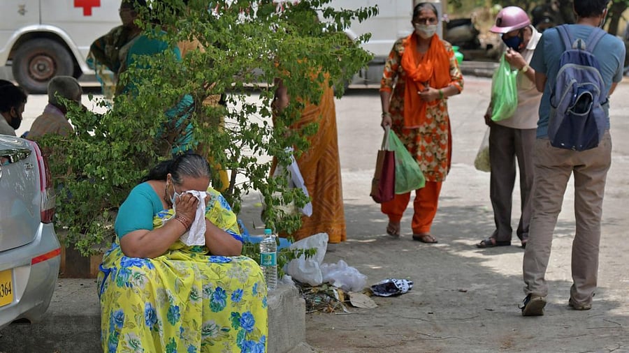 A woman weeps as she with other family members attend the last rites of a deceased who died of the coronavirus disease at a crematorium in Bangalore. Credit: AFP photo.