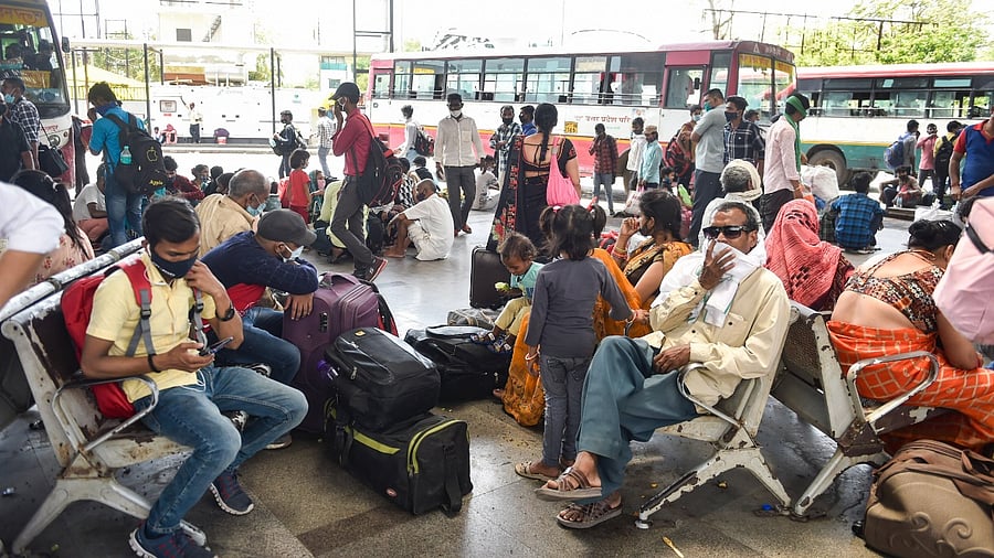 Migrants wait to board at Alambagh Bus Station in Lucknow. Credit: PTI Photo