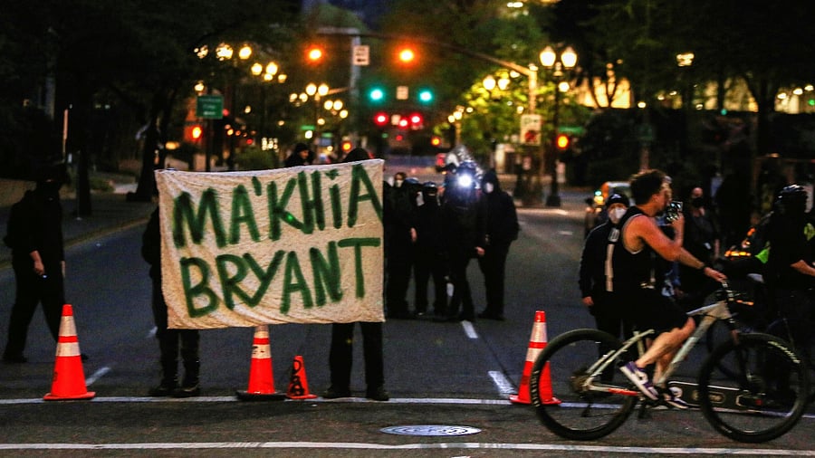 Protesters hold a sign to honor Ma'Khia Bryant, a Black girl who was fatally shot by a police officer in Columbus, Ohio. Credit: Reuters Photo