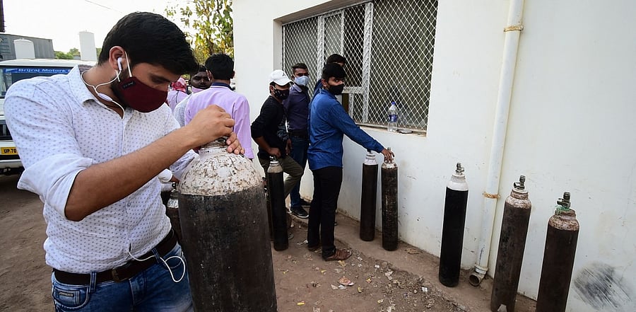 People wait to refill medical oxygen cylinders. Credit: AFP Photo/ Representative image
