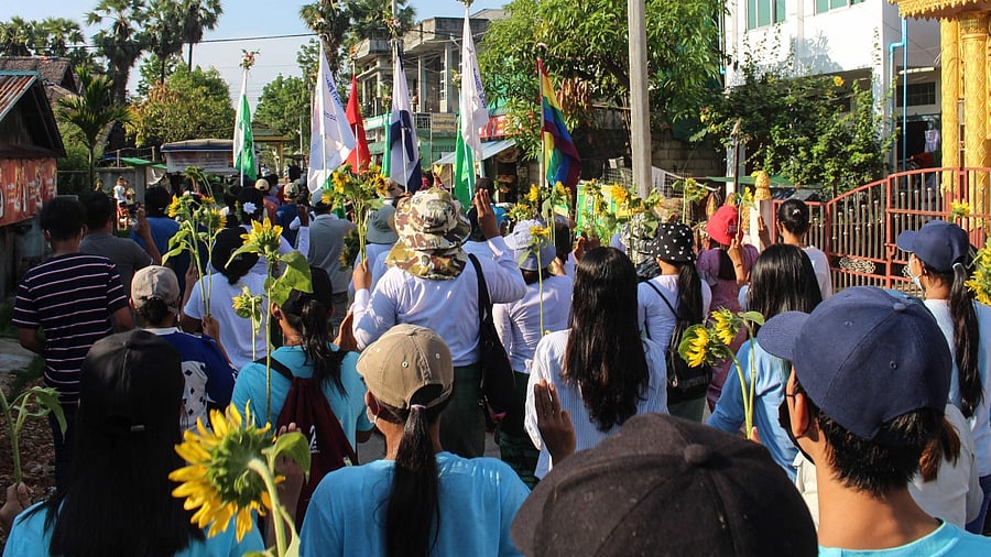 Protesters hold sunflowers during a demonstration against the military coup in Dawei. Credit: AFP Photo/Dawei Watch