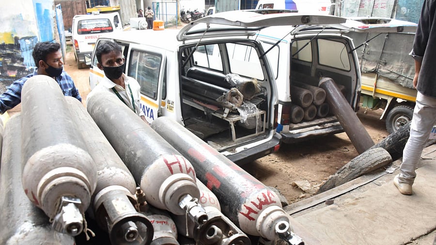 Hospital personnel queue for refilling oxygen cylinders at the Universal Air's refilling station at Peenya in Bengaluru. Credit: DH photo.