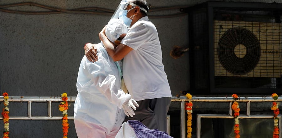 Relatives wearing personal protective equipment (PPE) mourn a man, who died from the coronavirus disease (COVID-19), next to his funeral pyre at a crematorium in New Delhi, India April 21, 2021. Credit: Reuters Photo