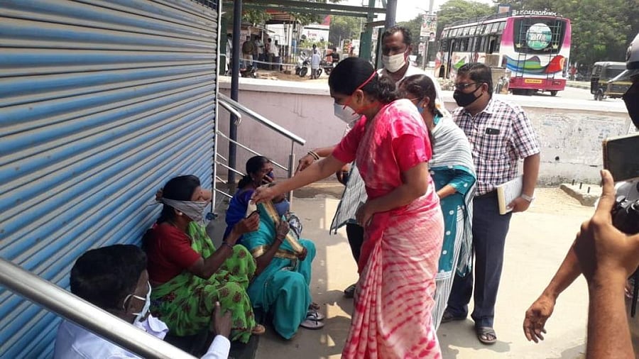 Deputy Commissioner S Aswathi educating the public on wearing masks in Mandya on Tuesday. DH PHOTO