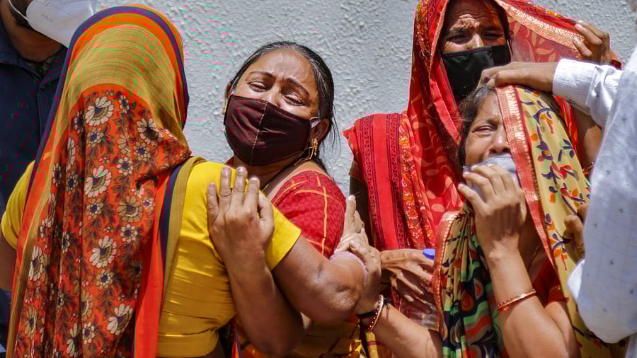 Family members react on the death of a relative, who died of COVID-19, as coronavirus cases surge across the country, outside a mortuary in Ahmedabad. Credit: PTI photo.