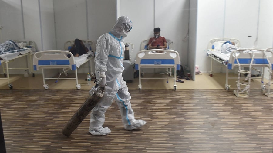 A doctor drags an oxygen cylinder at CWG village Covid-19 Care Centre near Akshardham, in New Delhi, Tuesday, April 20, 2021. Credit: PTI Photo