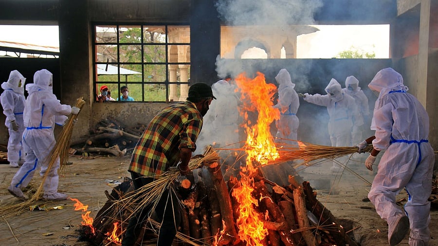 Family members, wearing protective suits, perform the last rites of a person who died of Covid-19, at Adarsh Nagar Moksha Dham in Jaipur, Tuesday, April 20, 2021. Credit: PTI Photo