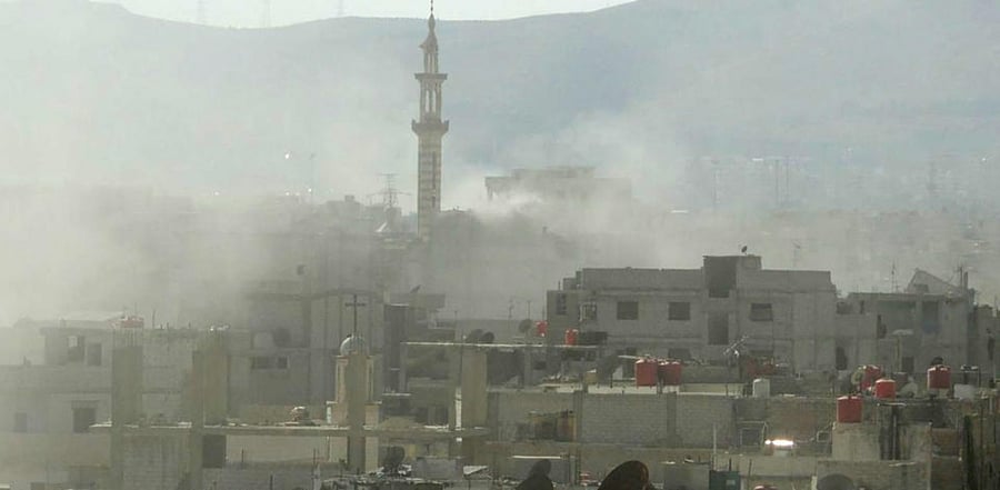 This file handout image released by the Syrian opposition's Shaam News Network shows smoke above buildings following what Syrian rebels claim to be a toxic gas attack by pro-government forces in eastern Ghouta, on the outskirts of Damascus on August 21, 2013. Credit: AFP Photo