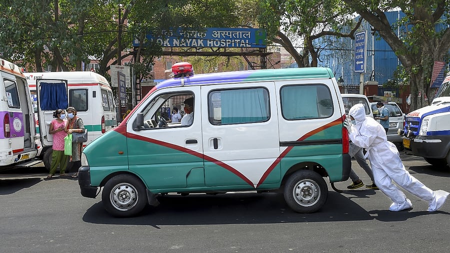 Medics push a stalled ambulance, with a Covid-19 patient inside, outside Lok Nayak Jaiprakash Narayan Hospital, in New Delhi. Credit: PTI photo